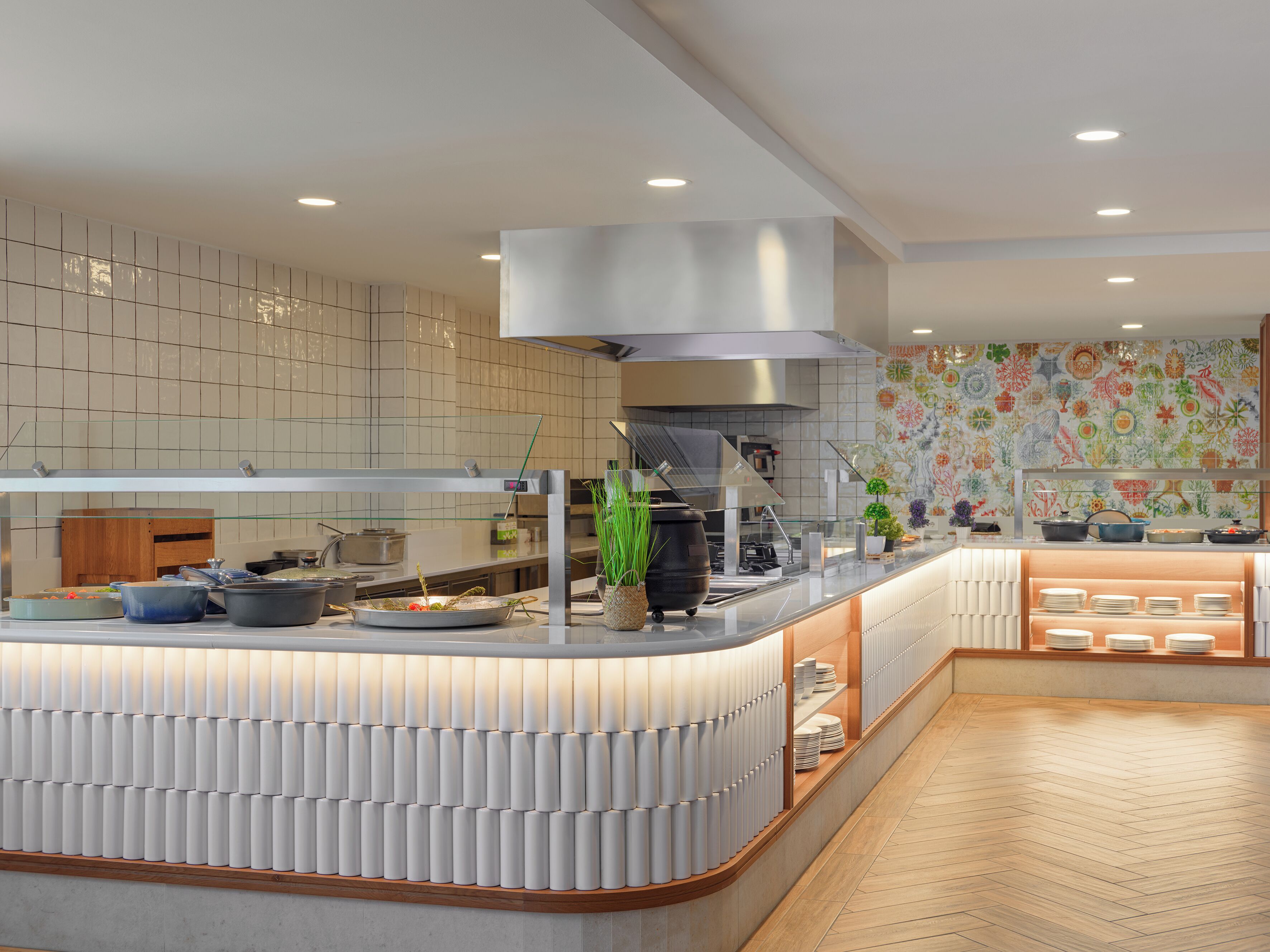 Een moderne keuken met een centraal eiland, roestvrijstalen apparatuur en een decoratieve spatwand.