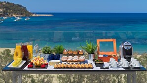 A breakfast buffet table with various food items and a coffee machine, overlooking a coastal view. - H10 Casa del Mar (Calvia)