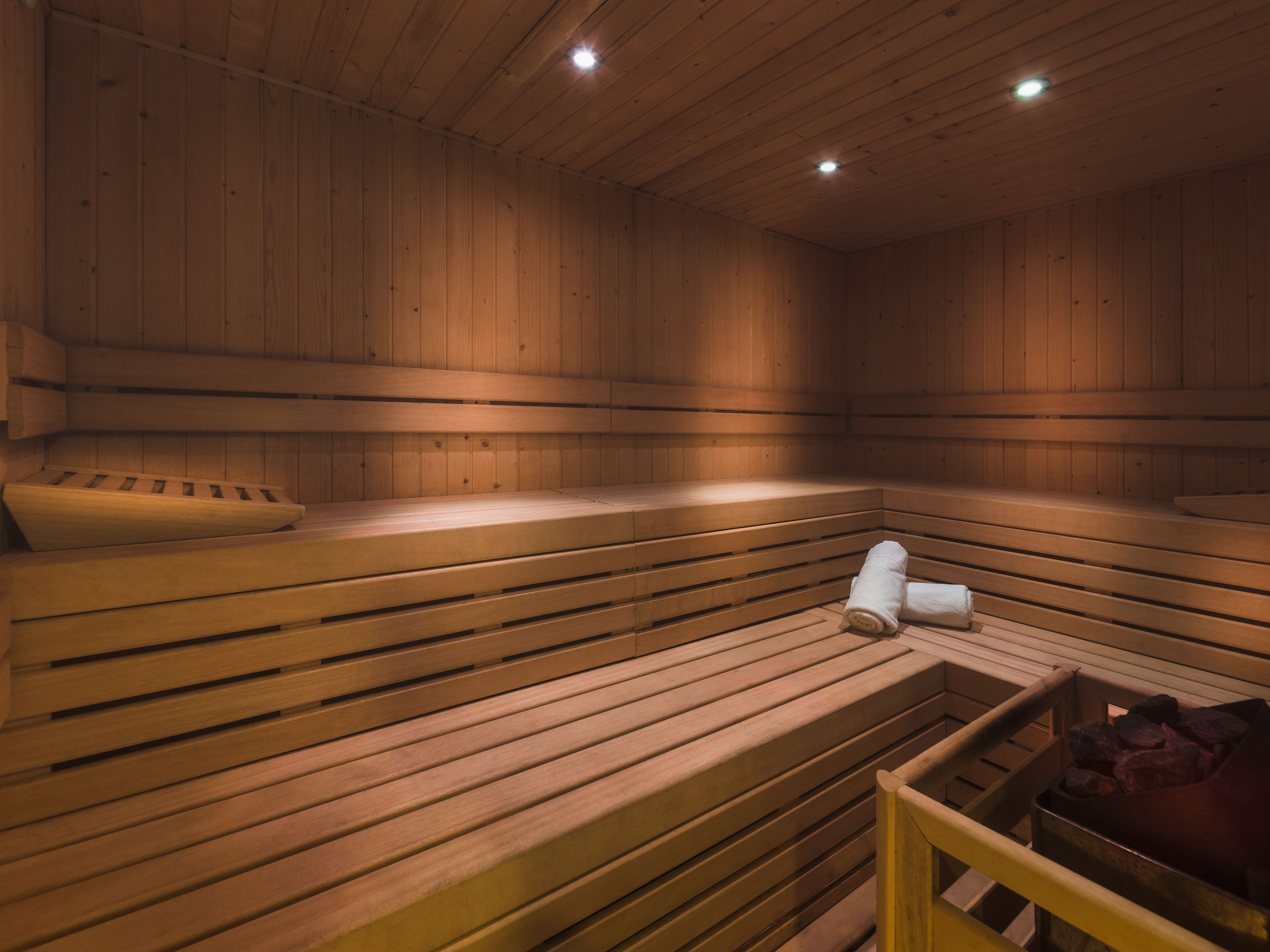 A sauna with wooden benches and a bench with a towel.