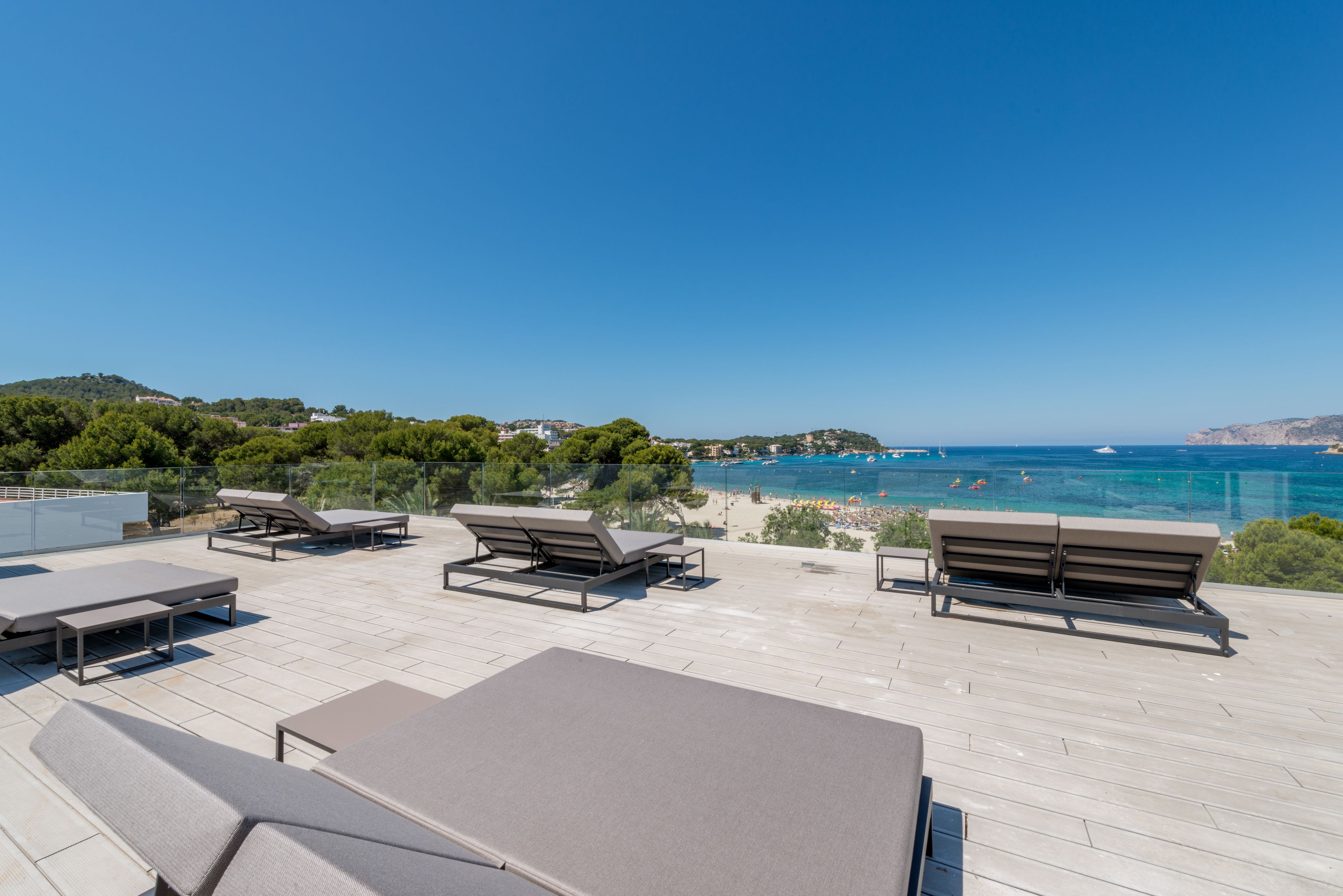 Terraza en la azotea con sillones de descanso y vista a la playa y al mar.