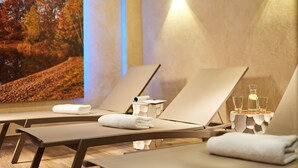 Un cuarto de spa con dos sillones reclinables, cada uno con una toalla y un vaso de agua.