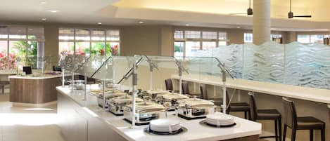 A buffet area with multiple serving stations, a central counter, and seating arrangements.