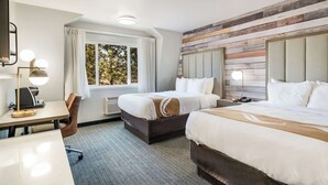 A hotel room with two beds, a desk with a lamp, a chair, and a window with curtains. - Quality Inn South Lake Tahoe (South Lake Tahoe)