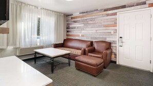 A modern room with a brown leather sofa, a small table, and a patterned rug. - Quality Inn South Lake Tahoe (South Lake Tahoe)