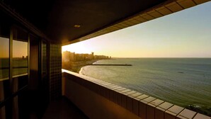 Varanda com vista para o mar e o horizonte distante da cidade.