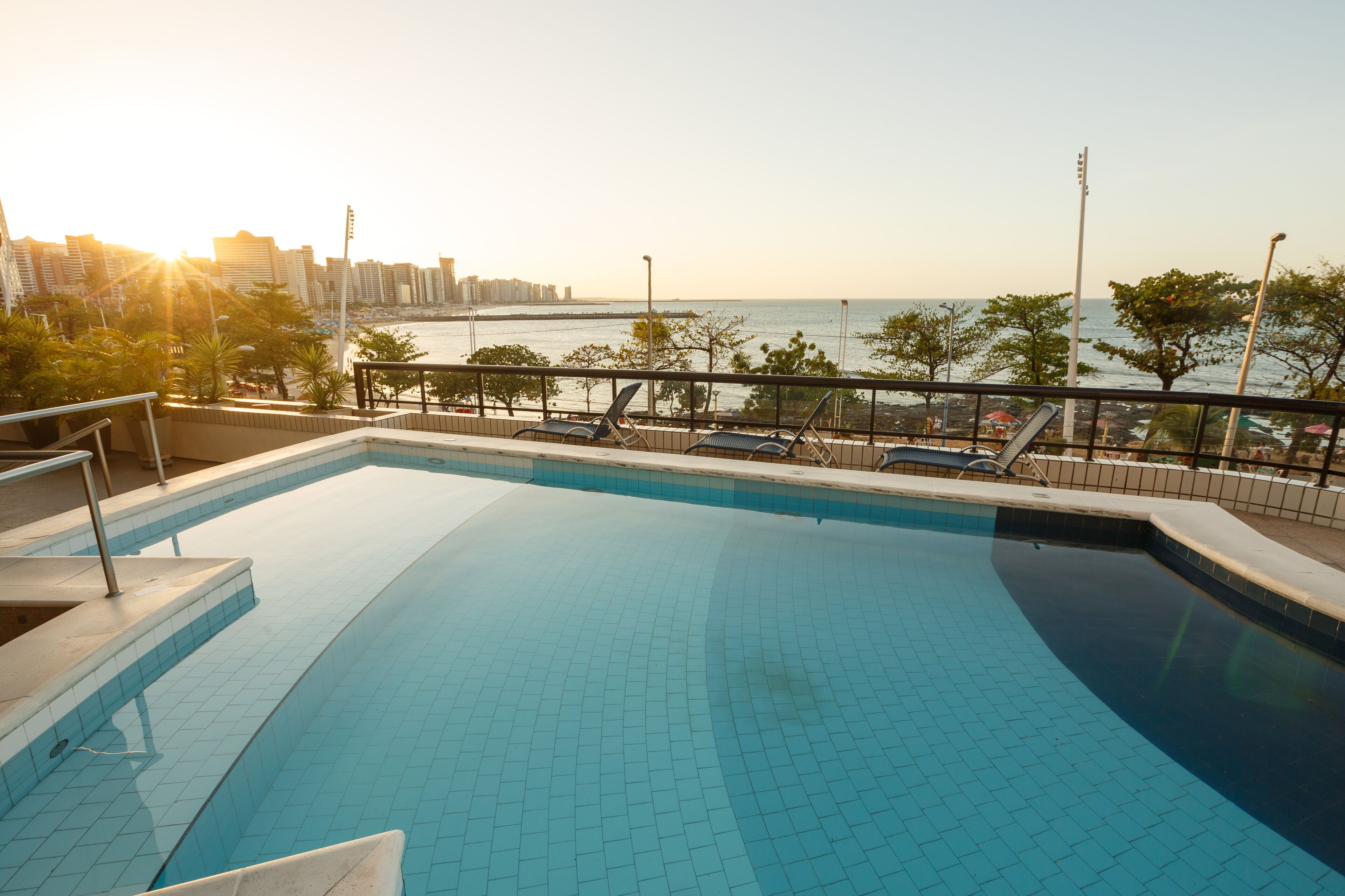 Une piscine offrant une vue sur les gratte-ciel de la ville et sur la mer.