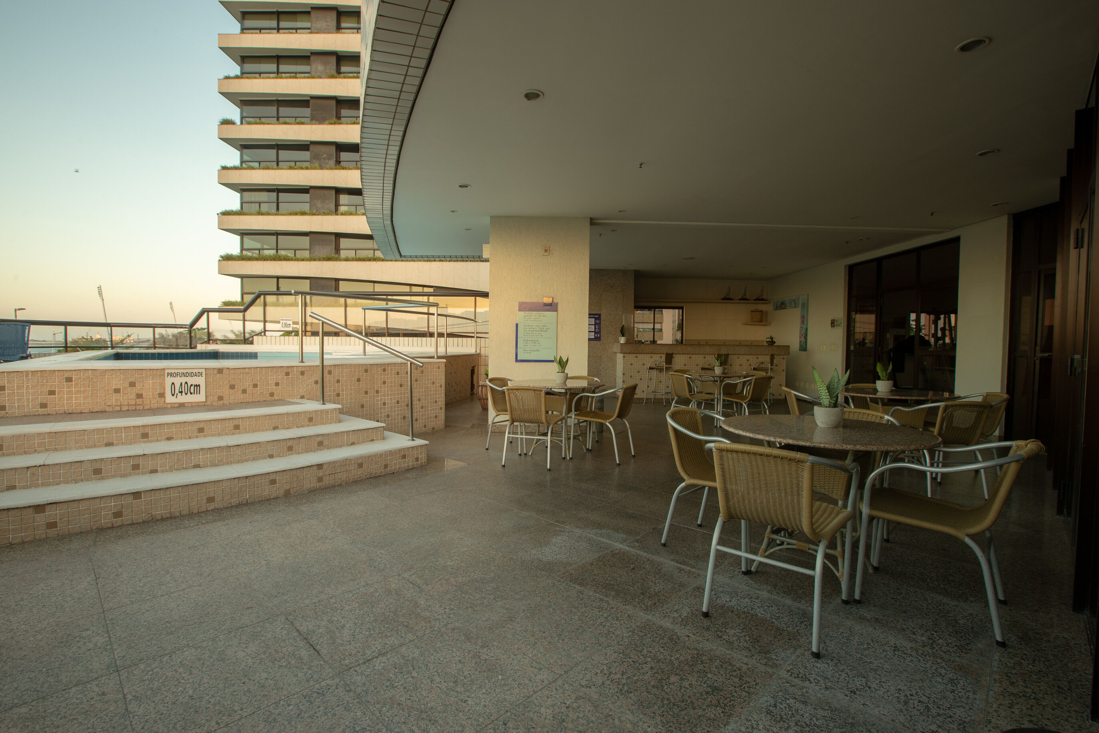 Eine Dachterrasse mit Pool, Sitzgelegenheiten im Freien und einer Treppe, die zu einer höheren Ebene führt.