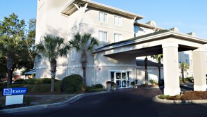 A Sleep Inn hotel with a prominent sign, a covered entrance, and a well-maintained entrance area with palm trees. - Sleep Inn North Charleston Ashley Phosphate (North Charleston)