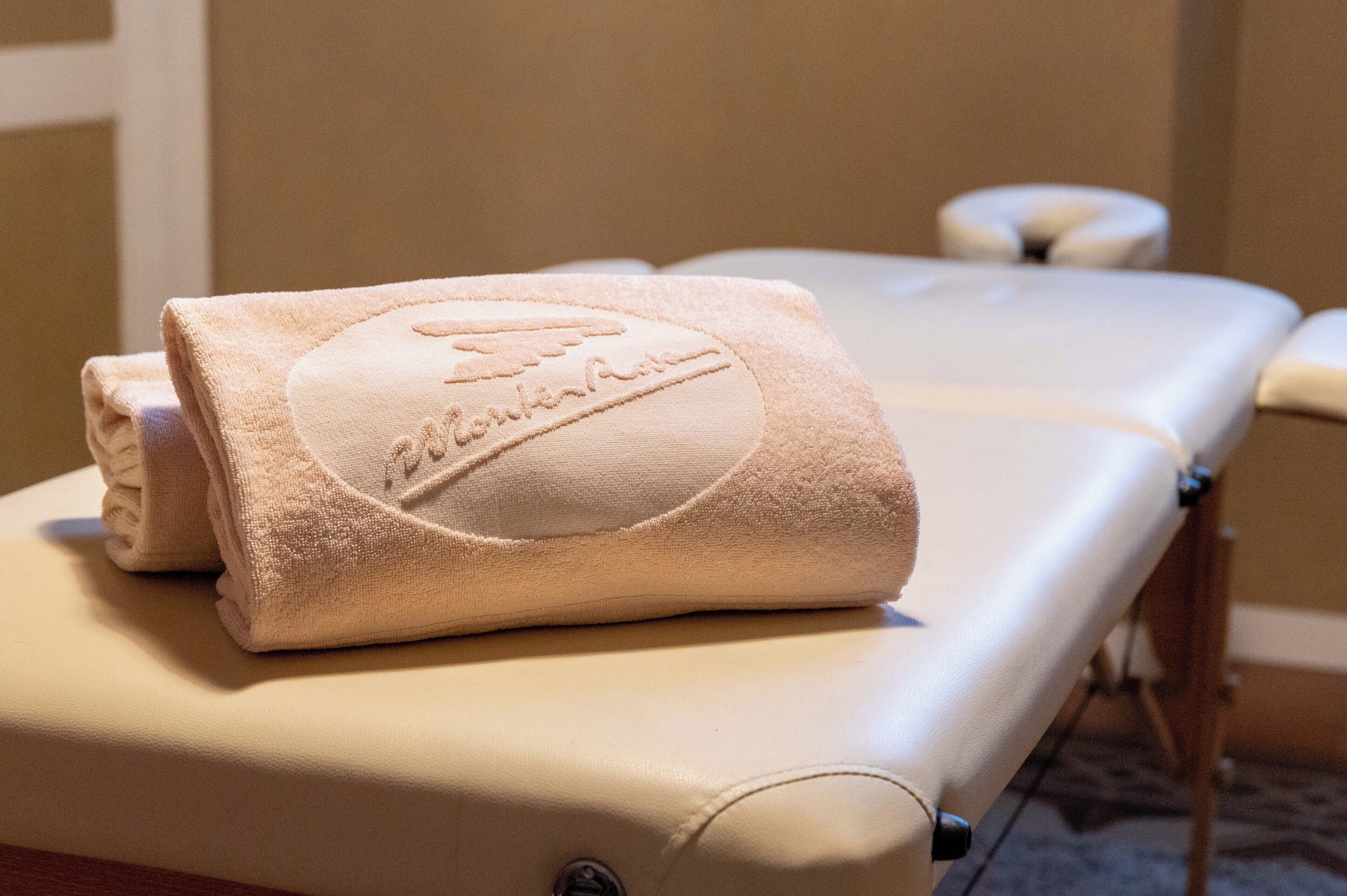 Ein Massagetisch mit gefaltetem Handtuch.