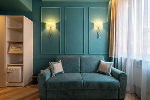 Relax in this stylish living room with a sofa, shelving unit, and unique light fixtures.
