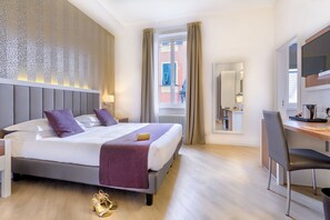 A modern hotel room with a large bed, a desk, and a view of the city.