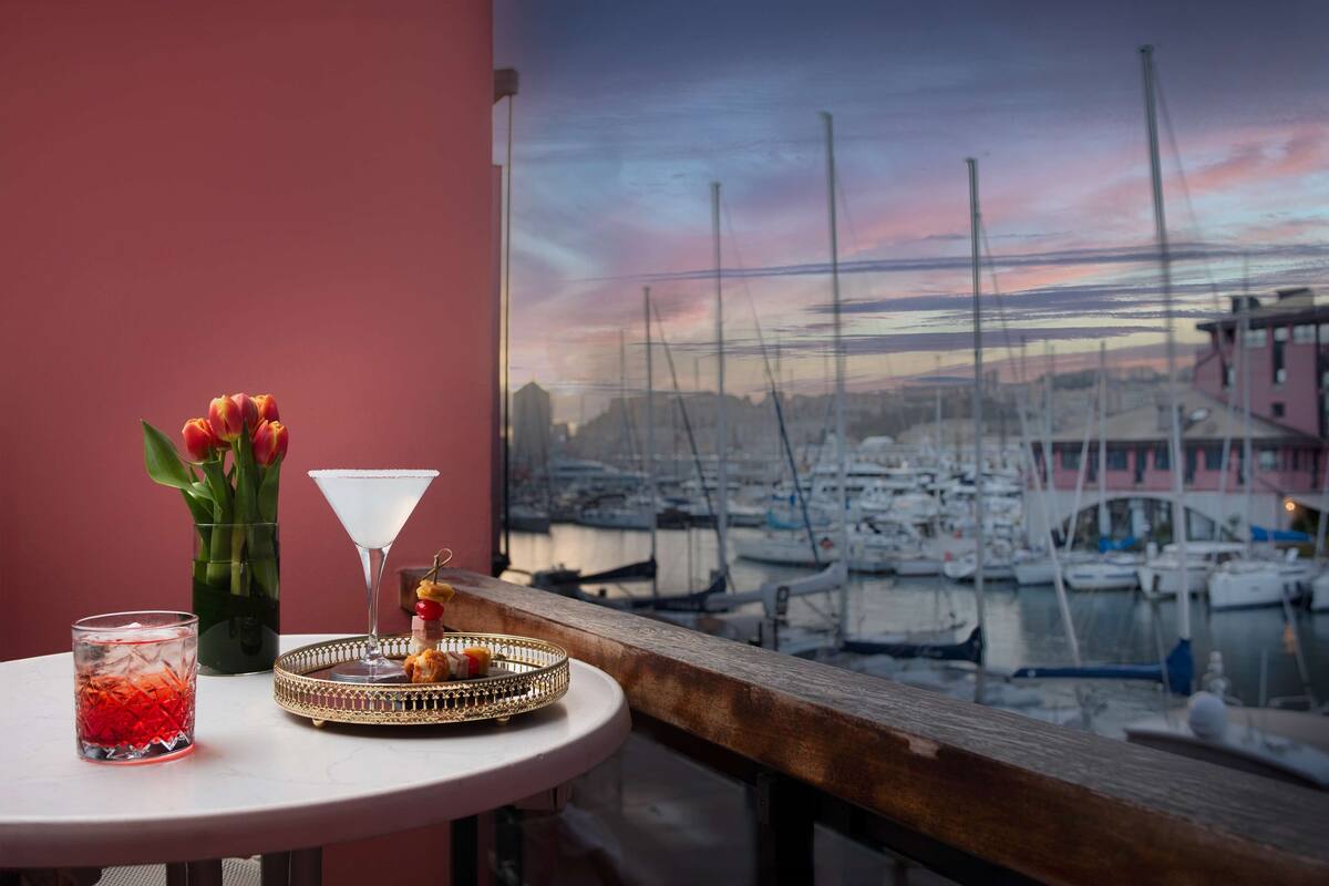 A table with a martini glass, a tray with snacks, and a vase of tulips.