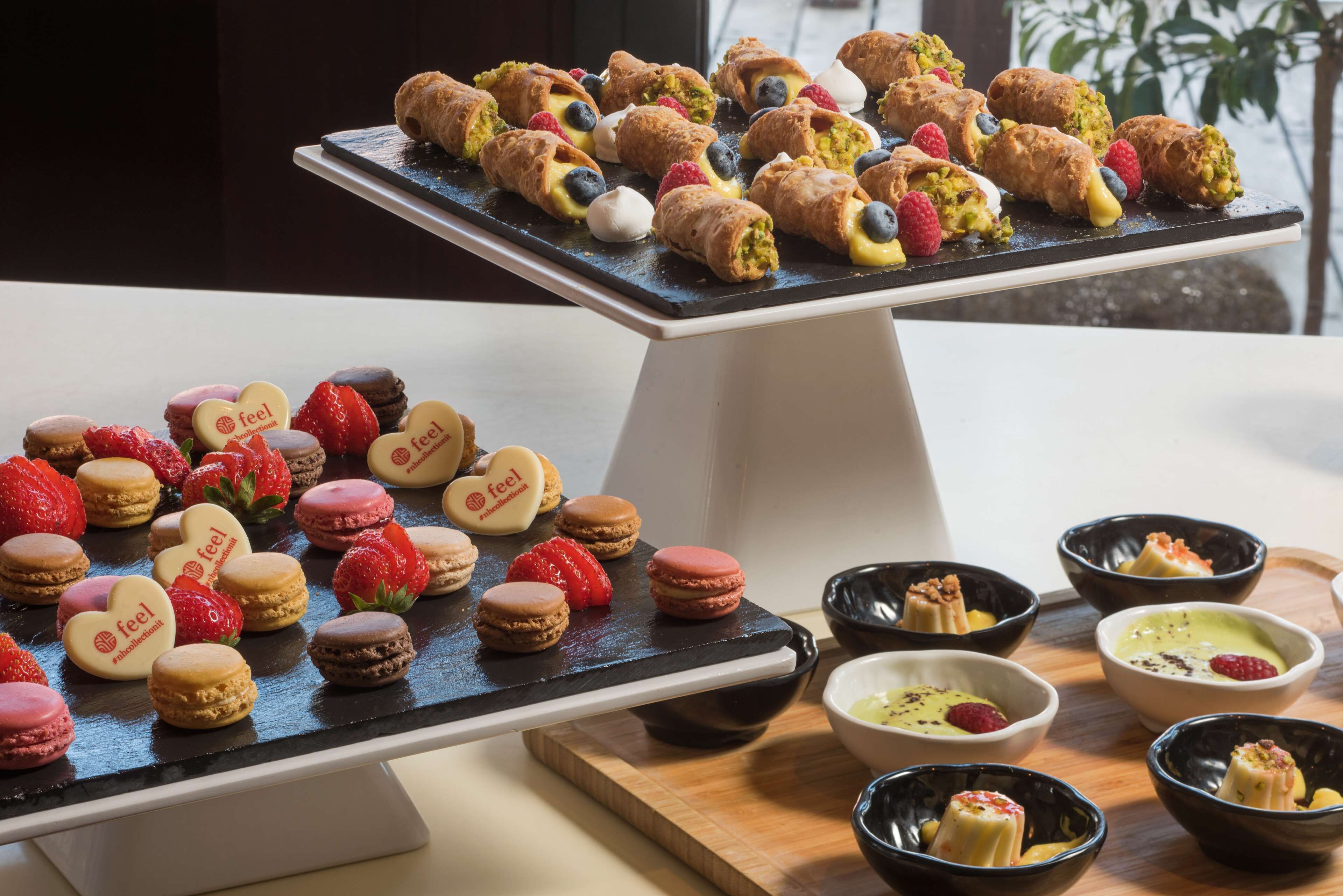A dessert display with macarons, pastries, and small bowls of desserts.