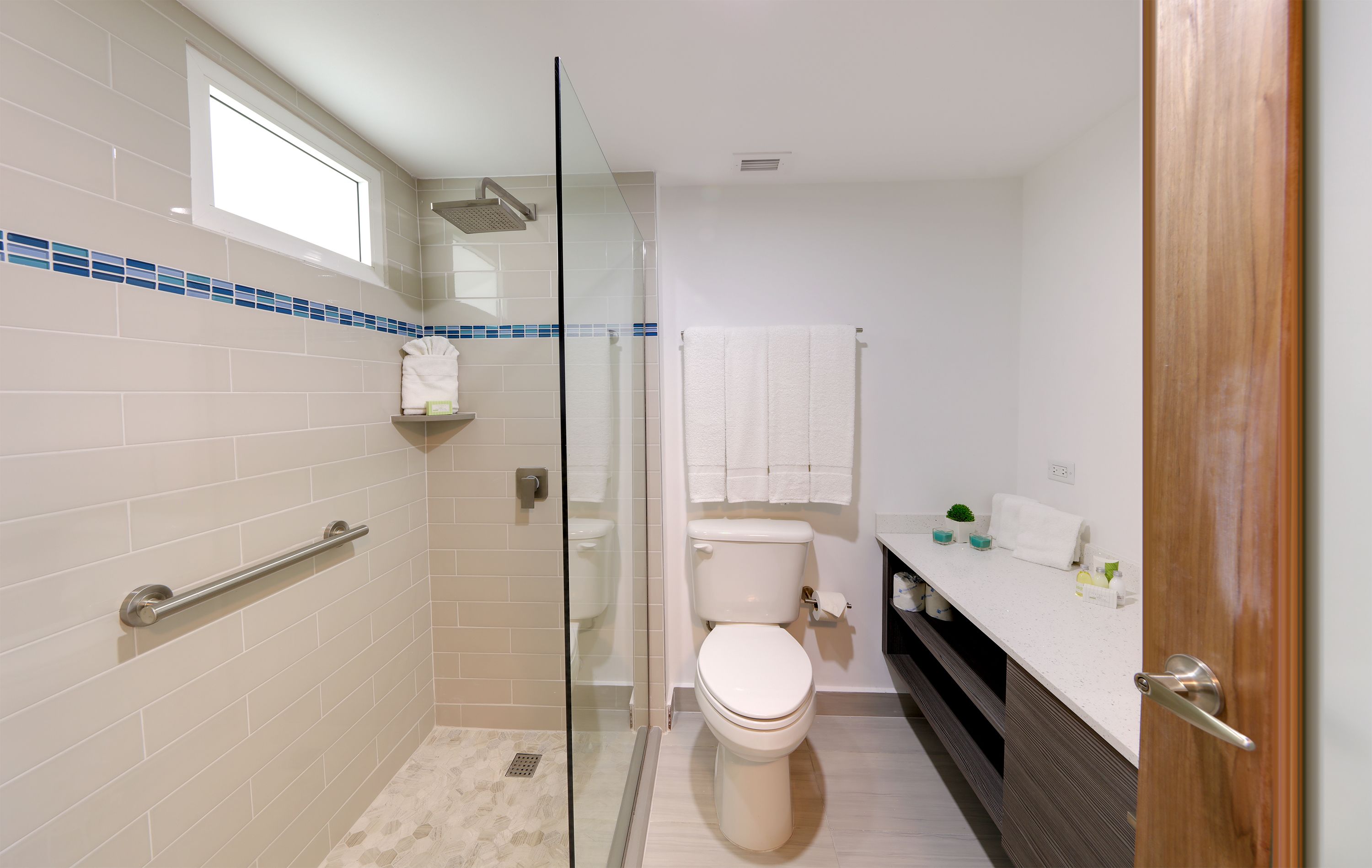 Un bagno moderno con box doccia in vetro, un water e un mobile lavabo con porta asciugamani.