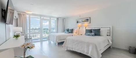 Une chambre d’hôtel moderne avec deux lits, une grande fenêtre et un balcon.