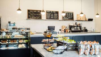 A cafe with a counter, display cases, and hanging lights.