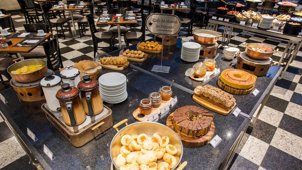 Un bufé con diversos alimentos y un letrero que dice "Café da Manha da Fazenda".