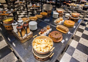 A buffet with various food items and a sign that reads "Café da Manha da Fazenda". - Estanplaza Funchal - Faria Lima (São Paulo)