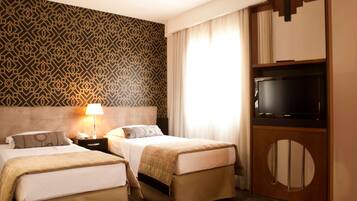 Ein Hotelzimmer mit zwei Betten, einem Fernseher und einer Wand mit Muster.