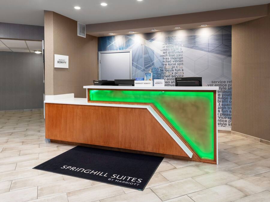 A reception desk with a modern design, a digital display, and a sign for Marriott Bonvoy.