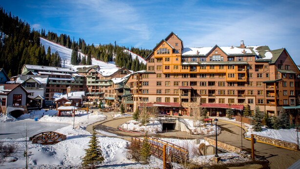 A multi-story hotel with a ski slope in the background. - Zephyr Mountain Lodge (Winter Park)