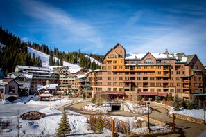 A multi-story hotel with a ski slope in the background. - Zephyr Mountain Lodge (Winter Park)
