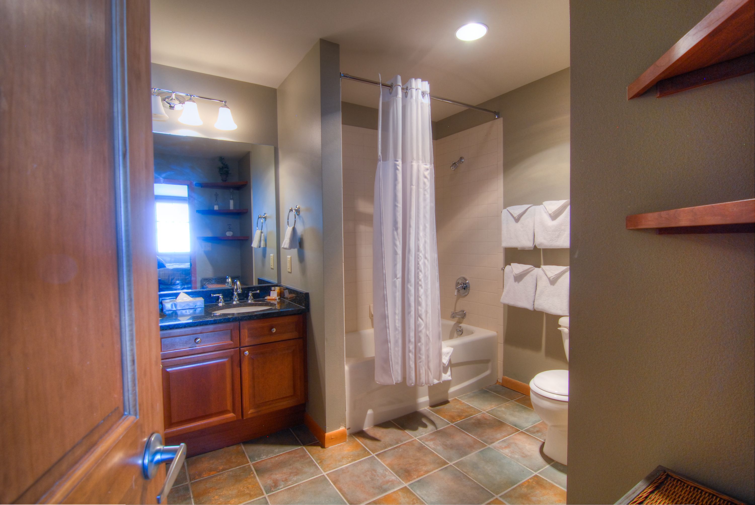 A bathroom with a shower, toilet, and sink.
