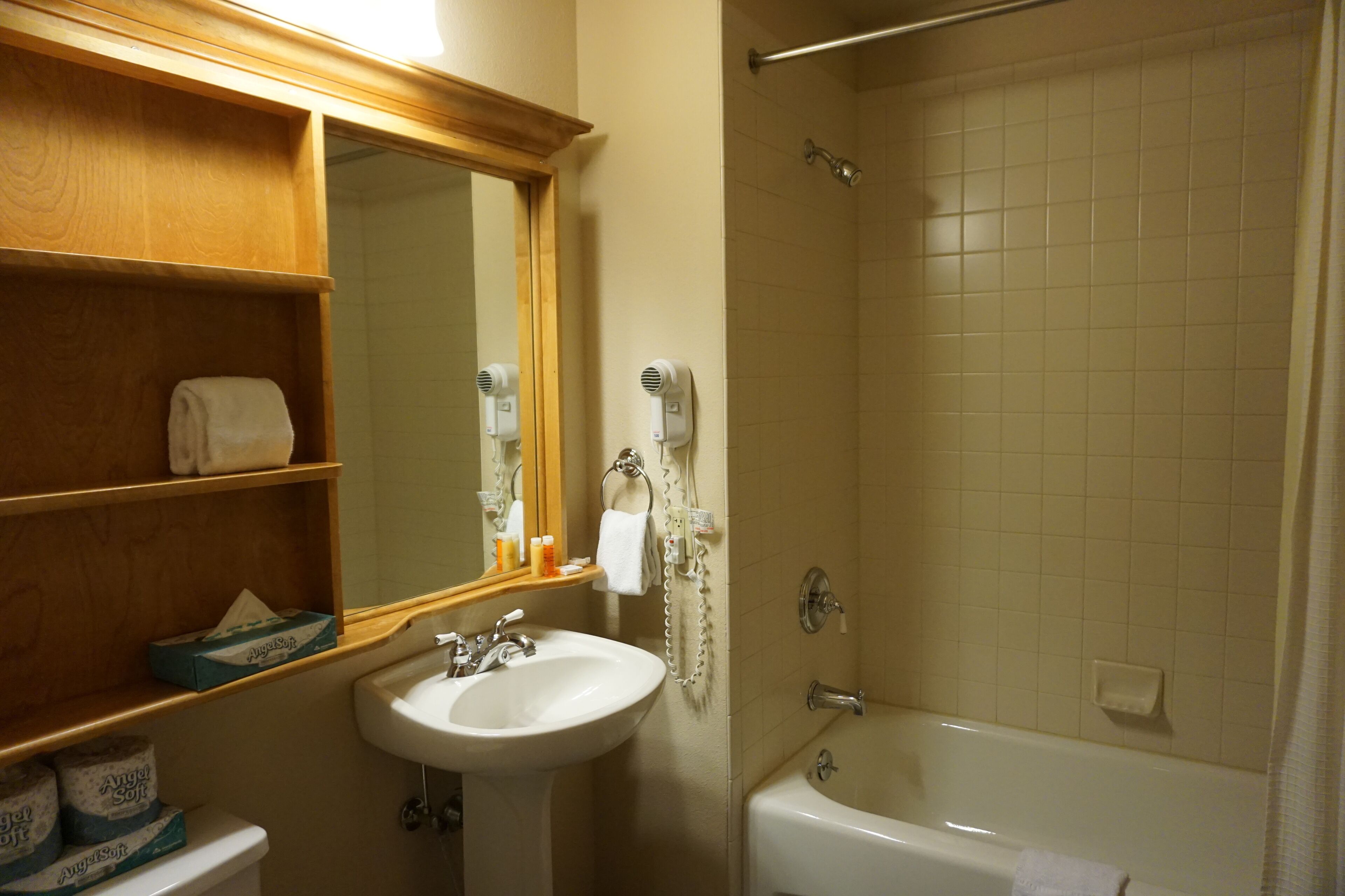 Un baño con lavamanos, espejo y ducha.