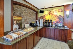 Un coin café avec un mur en pierre, une enseigne indiquant qu'il s'agit d'un café, et divers équipements pour préparer le café.