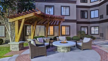 A patio area with outdoor seating and a fire pit.