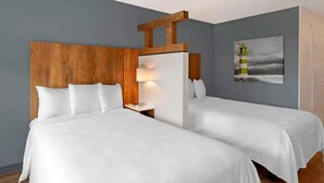 A hotel room with two beds, a wooden headboard, a nightstand with a lamp, and a painting of a lighthouse. - Extended Stay America Premier Suites Miami Downtown Brickell (Miami)