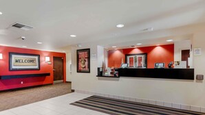 A reception area with a 'WELCOME' sign, a reception desk, a door, and a tiled floor.