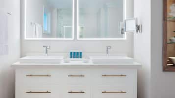 A modern bathroom with two sinks, a large mirror, and a cabinet with drawers.