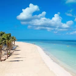 On the beach, white sand, beach cabanas, sun loungers