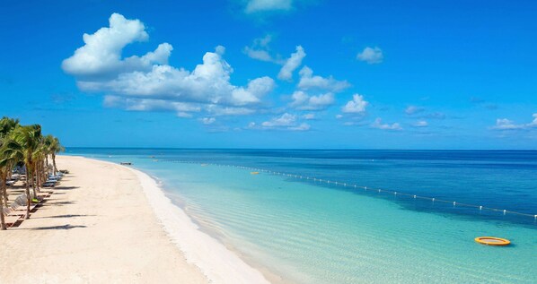 On the beach, white sand, beach cabanas, sun-loungers