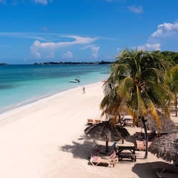 On the beach, white sand, beach cabanas, sun loungers