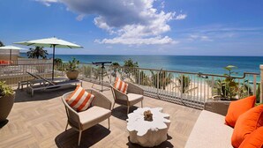 A balcony with wicker furniture, a telescope, and a view of the ocean. - Beaches Negril Resort - ALL INCLUSIVE (Negril)