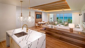 A modern kitchen with a marble countertop, wooden flooring, and a dining area with a view of the ocean. - Beaches Negril Resort - ALL INCLUSIVE (Negril)