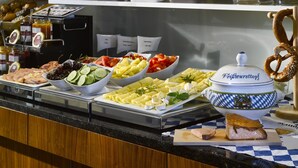 Un bufé con diversos alimentos, como pan, frutas, quesos y carnes.