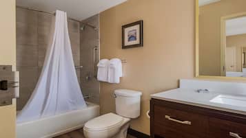 Een badkamer met douche, toilet en wastafel.