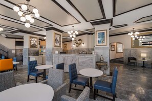 Experience the sleek lobby with a central reception area, comfortable seating, and a grand staircase.