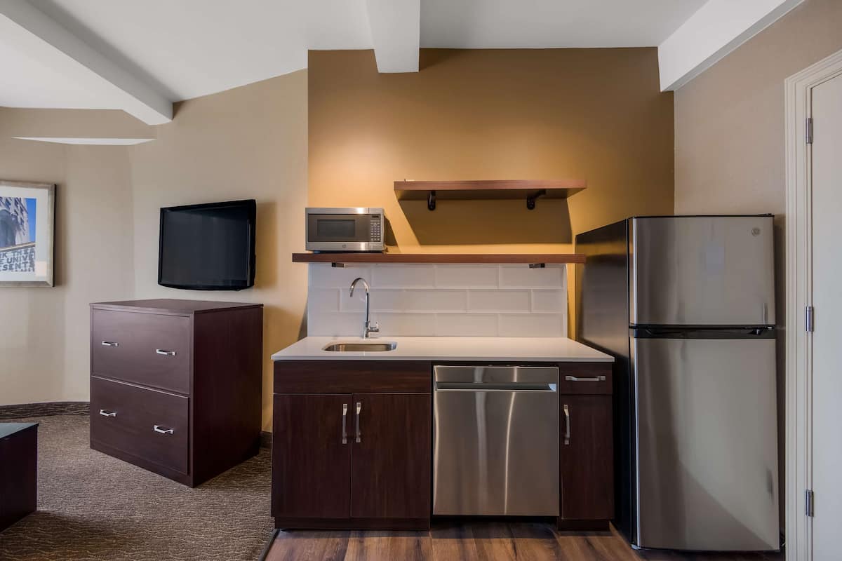 A compact kitchen with a microwave, dishwasher, and refrigerator.