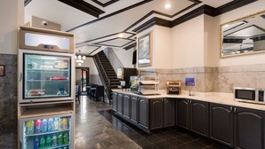 Una cocina moderna con refrigerador, microondas y cafetera.