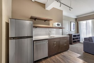 Una cocina compacta con refrigerador, microondas y lavamanos.