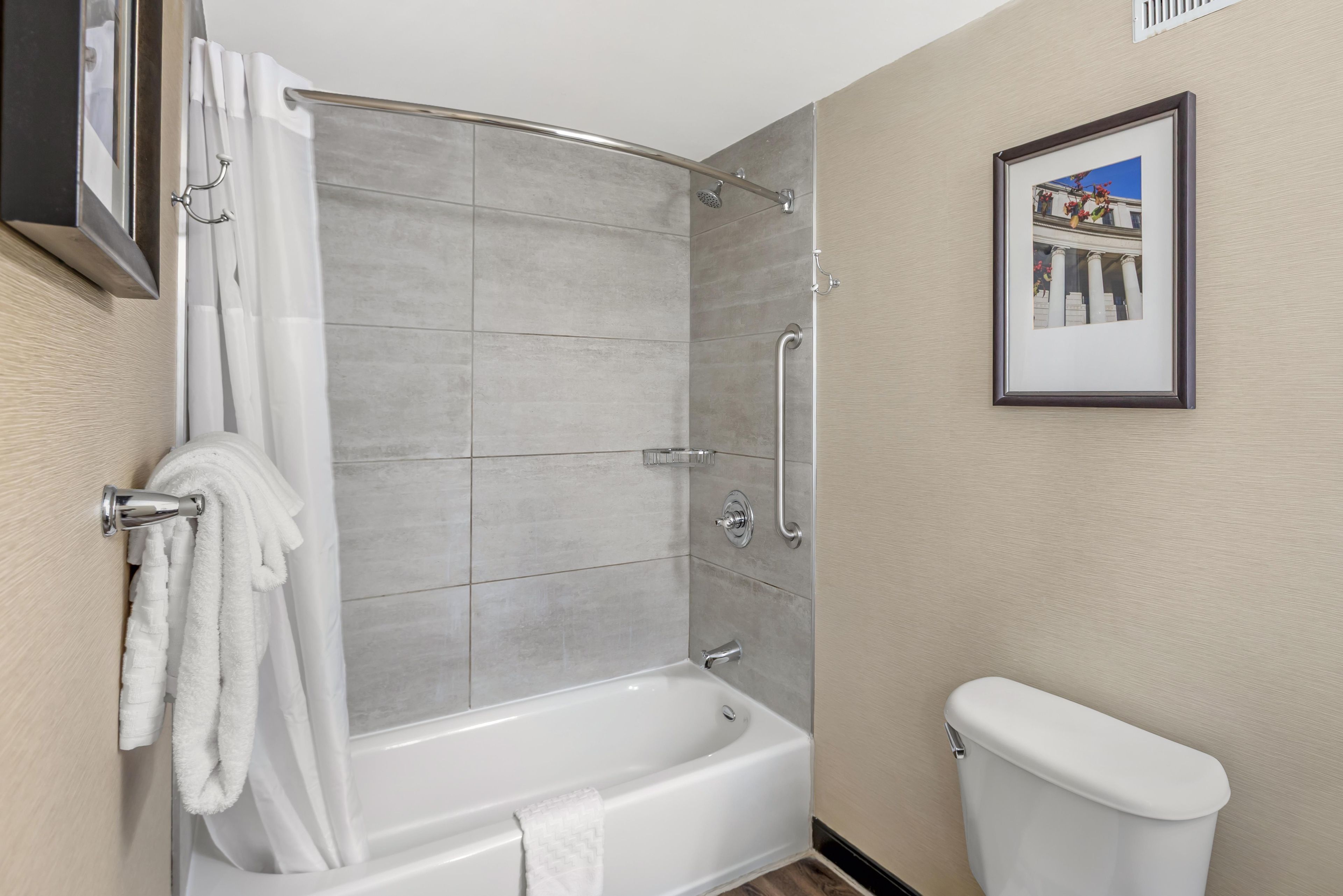 A bathroom with a shower, a bathtub, and a toilet.