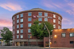 Un edificio de ladrillo con varias ventanas y un letrero que dice 'Roundhouse Suites'.