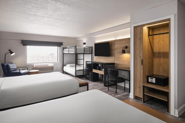 A modern hotel room with bunk beds, a desk, a chair, a TV, and a wardrobe. - Aiden by Best Western Newark Airport (Newark)