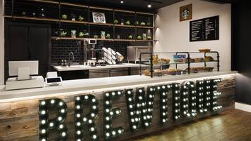 A coffee shop counter with a sign that reads 'BREW TIME,' a menu board, and shelves with plants and coffee equipment.