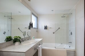 Suite, 1 King Bed, Corner | Bathroom | Combined shower/bathtub, rainfall showerhead, free toiletries