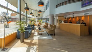 A modern lobby with seating areas, a reception desk, and large windows. - Palladium Business Hotel (Montevideo)